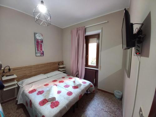 a bedroom with a bed with flowers on it at B&B del Viale in LʼAquila