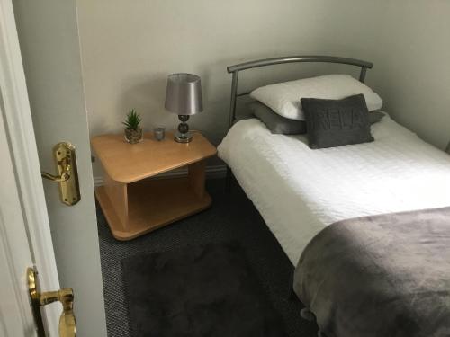 um quarto com 2 camas e uma mesa com um candeeiro em Glenview Self Catering Holiday Home em Portrush