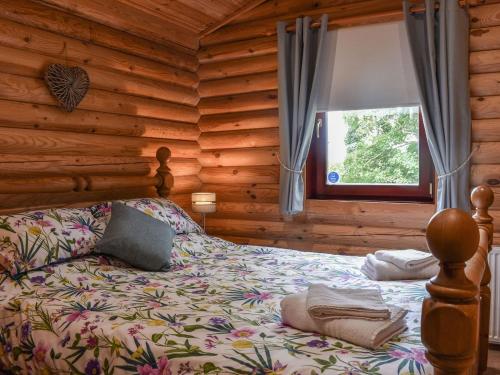 a bedroom with a bed in a log cabin at Felmoor Park - Mystic Falls in Felton