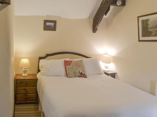 a bedroom with a bed with white sheets and two lamps at Mill Apartment - Ukc3784 in West Down