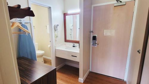a bathroom with a sink and a toilet and a mirror at Studios & Suites 4 Less Charlotte in Charlotte