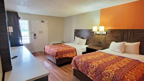 a hotel room with two beds in a room at Studios & Suites 4 Less Charlotte in Charlotte