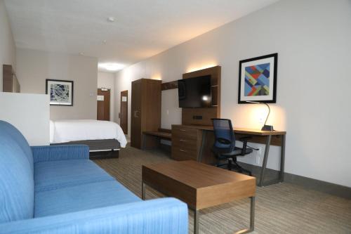 a hotel room with a bed and a couch and a desk at Holiday Inn Express Hotel & Suites Albuquerque Airport by IHG in Albuquerque