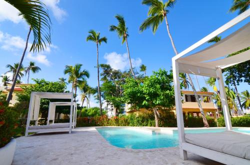 a bed and a gazebo next to a pool at Resort Atlantic Villas & Spa in Punta Cana