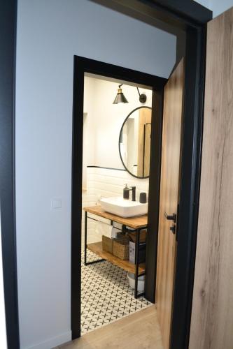 La salle de bains est pourvue d'un lavabo et d'un miroir. dans l'établissement Norda Loft, à Dębki