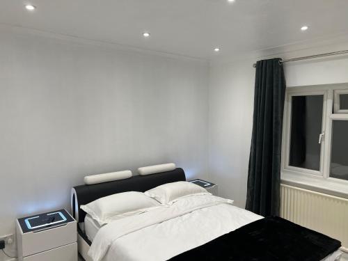 a bedroom with a bed with white sheets and a window at The Elegance in Chatteris