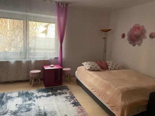 a bedroom with a bed and a window with pink curtains at Ferienwohnungen Berg & See in Döbriach