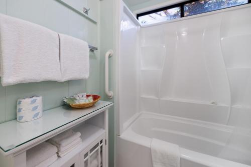a white bathroom with a tub and a shower at Coastal Coziness in Cayucos