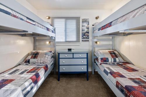 two bunk beds in a room with a blue dresser at Coastal Coziness in Cayucos