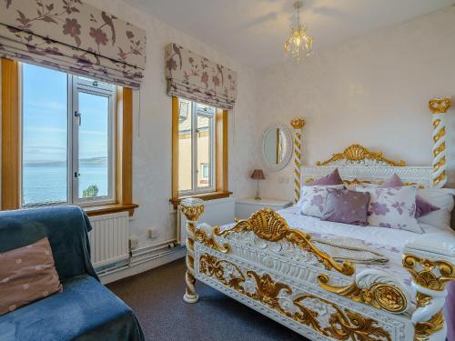 1 dormitorio con ventanas y cama blanca y dorada en The Wee Nunnery - Uk7123, en Skelmorlie