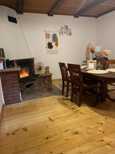 a living room with a table and a fireplace at Całoroczny domek rustykalny in Siemiatycze