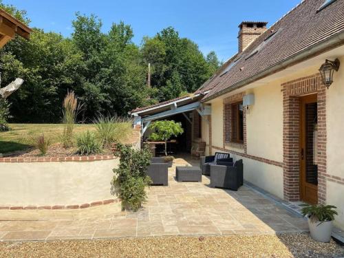 a patio of a house with couches and a table at Gîte Normand 26 couchages in Rai-sur-Rîle