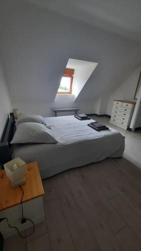 a bedroom with a bed and a table and a window at Gîte Normand 26 couchages in Rai-sur-Rîle