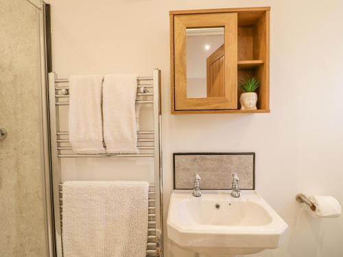 a white bathroom with a sink and a mirror at Bluebell in Swadlincote