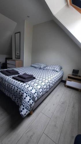 a bedroom with a bed with a black and white comforter at Gîte Normand 26 couchages in Rai-sur-Rîle