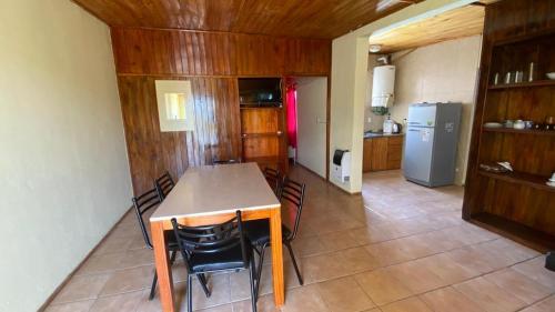 聖拉斐爾的住宿－Departamentos Gattelli，厨房配有桌椅和冰箱。