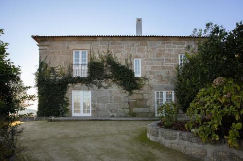 an old stone house with ivy at Casa da Ribeira in Marco de Canavezes