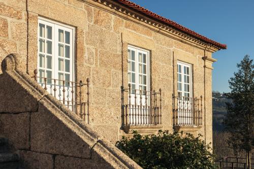 a building with three windows and a staircase at Casa da Ribeira in Marco de Canavezes