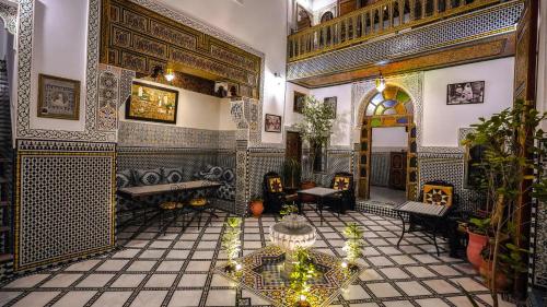 a room with a table and chairs in a building at Riad Green House in Fez