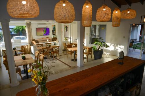 a dining room with tables and chairs and pendant lights at HAS Hotel Boutique in Bella Unión