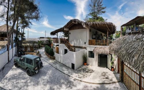 ein grünes Auto, das vor einem Haus parkt in der Unterkunft Tres Palmas in Montañita