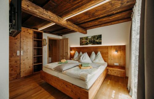 ein Schlafzimmer mit einem großen Bett in einem Zimmer mit Holzdecken in der Unterkunft Bauernhof Unterbichl in Flachau