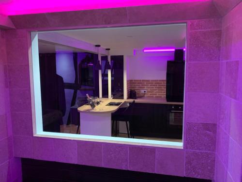 Habitación púrpura con cocina con mesa. en Le Jacuzzi en Ruan