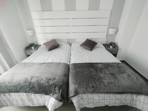 a bedroom with two beds and two night stands at Apartamento Ana Maria in San Juan del Puerto