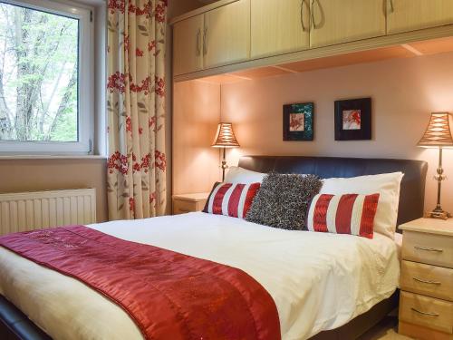 a bedroom with a large bed and a window at Treetops in Bowness-on-Windermere