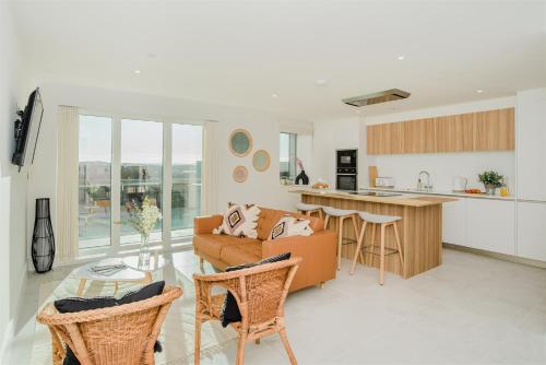 a living room and kitchen with a couch and a table at 7 Cliff Edge in Newquay
