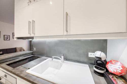 a kitchen with a white sink and a stove at Le Cocon - 5 min RER A - 10 min Paris in Fontenay-sous-Bois