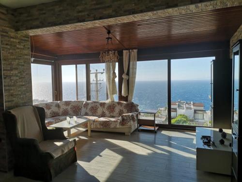 a living room with a couch and a view of the ocean at YALIKAVAK KIZILBURUNDA FIRSAT TATİL EVİ in Bodrum City