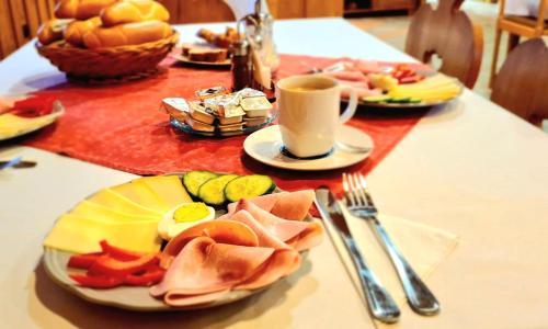 a table with plates of food and a cup of coffee at Horská Kvilda - Ubytování U Chvalů in Horská Kvilda