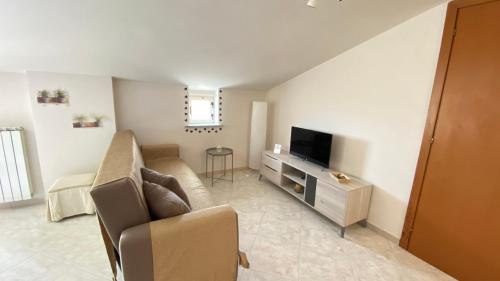 a living room with a couch and a television at TDC Home in Vallo della Lucania