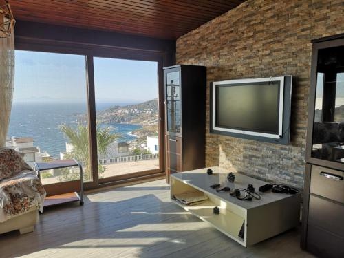 a living room with a television on a brick wall at YALIKAVAK KIZILBURUNDA FIRSAT TATİL EVİ in Bodrum City