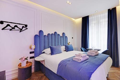 a bedroom with a large bed with a blue headboard at Couples Getaway Unit with Jacuzzi - City Center in Paris