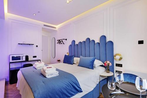 a bedroom with a large bed with blue pillows at Couples Getaway Unit with Jacuzzi - City Center in Paris