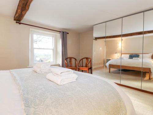 a bedroom with a large bed with towels on it at The Nook in Kirkoswald