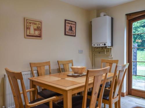 a dining room with a wooden table and chairs at Lily Cottage - Uk40101 in Dunvant