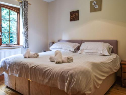 a bedroom with a large bed with slippers on it at Lily Cottage - Uk40101 in Dunvant