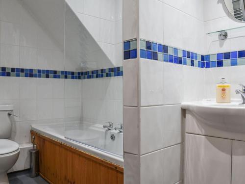 a bathroom with a tub and a toilet and a sink at Lily Cottage - Uk40101 in Dunvant