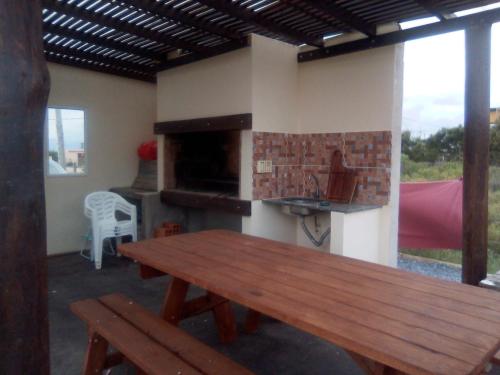 a patio with a wooden table and a fireplace at La Quijotada in Punta Colorada