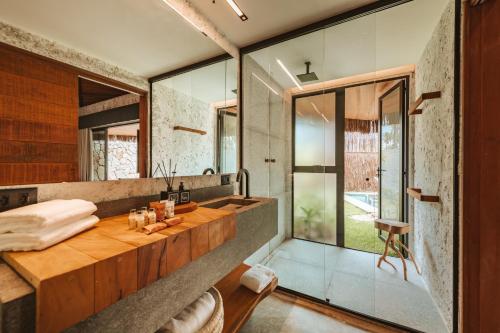 a bathroom with a sink and a large mirror at Tuju Boutique Hotel in Passo de Camarajibe