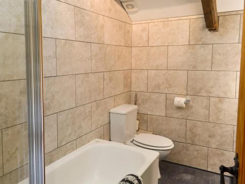 a bathroom with a toilet and a bath tub at The Pound House in Paignton