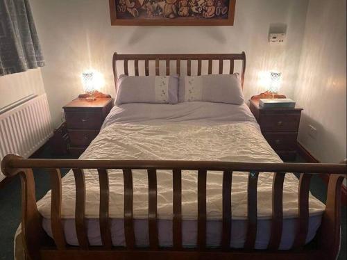 1 cama en un dormitorio con 2 mesitas de noche y 2 lámparas en Annie Dee’s Guest Accommodation, en Ballygowan