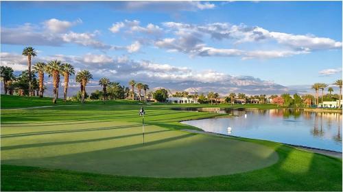a golfer on a golf course with a pond at Holiday Inn Express Palm Desert by IHG in Palm Desert