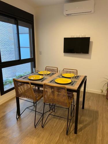 a dining room with a table with chairs and a television at Departamento para 2 personas in Rosario