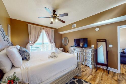 a bedroom with a white bed with a ceiling fan at Ariel Dunes I 1709 in Destin