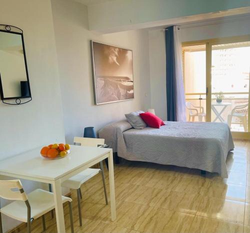 een slaapkamer met een bed en een tafel en een tafel bij Puerta del Sol TRM only adults Aparts in Torremolinos