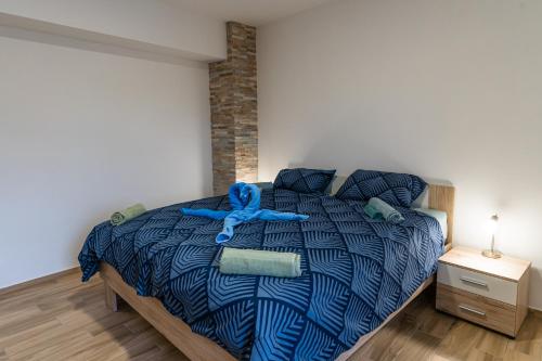 a bedroom with a bed with a blue comforter at Apartma Valič in Ajdovščina